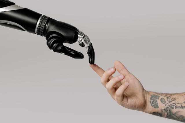 Robot arm en een mensenarm. De impact van Ai op het bedrijfsleven